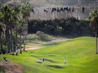 La partita di golf giocata mentre i migranti sono appesi al recinto della "Fortezza Europa"